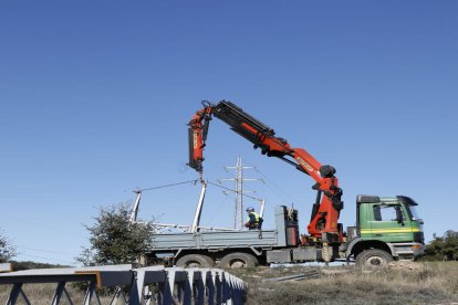 Operaris desmuntant la línia centenària al port de Comiols.