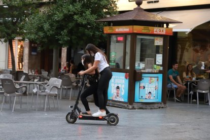 Dos joves circulant en patinet elèctric per l’Eix, ahir.