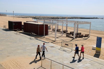 Algunas personas paseando ayer por el paseo marítimo de la playa del Bogatell en Barcelona.