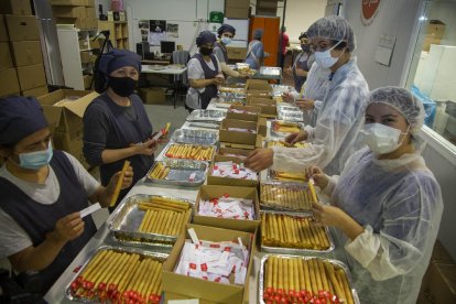 Trabajadores y voluntarios del obrador de galletas El Rosal preparando el pedido. 