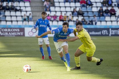 Pedro Martín intenza zafarse del marcaje de un jugador del Ejea, en una acción del partido de ayer en el Camp d’Esports.