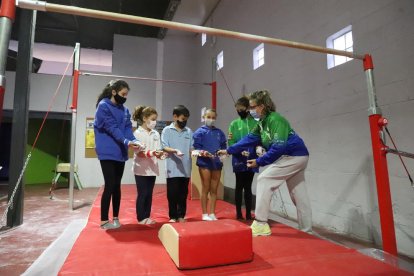 Un grupo de gimnastas del FEDAC reciben la tiza líquida de su entrenadora Maribel Moncasi ayer durante el entrenamiento.