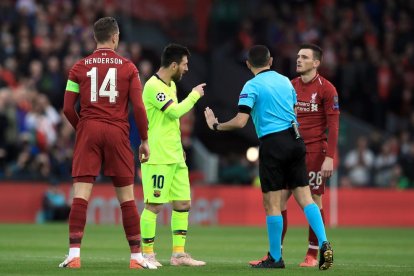 Leo Messi discute con el árbitro durante el encuentro disputado en Anfield.