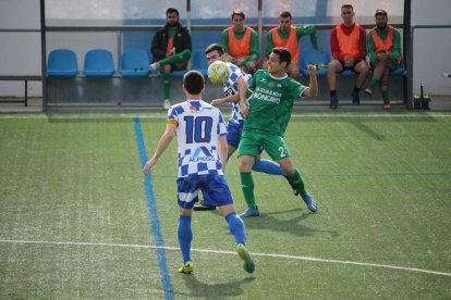 Un jugador del Tamarit lluita pel control de la pilota.