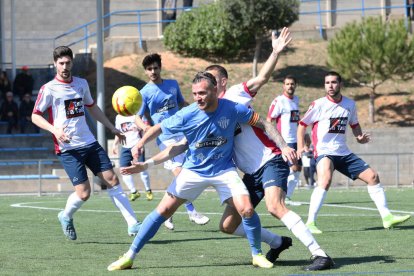 Un jugador de l’Alcarràs protegeix la pilota davant la pressió d’un defensor del Sant Ildefons.