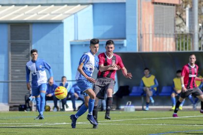 Un jugador del EFAC lucha por el control del balón con un jugador rival.