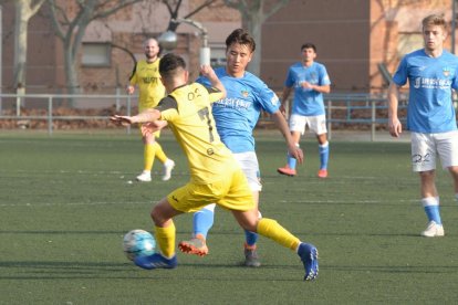 Liu, del Lleida B, y  Pablo Bernal, del Balaguer, pugnan por el balón.