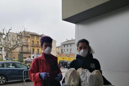 Dos de les voluntàries de Ponts abans d’entregar el menjar.