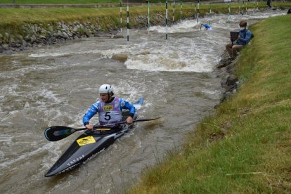 A primer terme, un palista ahir al canal olímpic d’aigües braves del Parc del Segre amb l’entrenador, darrere, amb màscara.