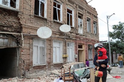 Un pare i el seu fill caminen pels carrers d’una Karabakh destruïda pels continus atacs.