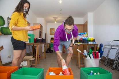 Dos monitors de Lleure Quàlia preparant material de protecció per a les activitats d’estiu.