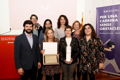 Gerard Esteva i integrants d’Esport Femení Lleida, amb Eva Ribalta mostrant la placa.