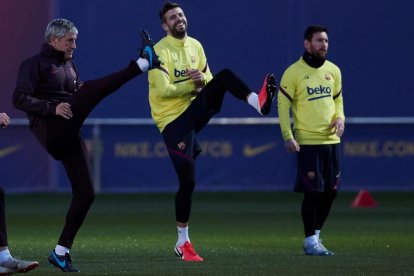 Piqué i Messi al costat de l’entrenador Quique Setién durant l’entrenament.