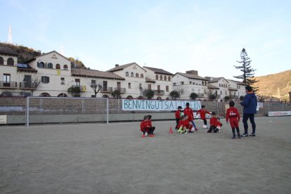 Un grupo de niños junto a su entrenador ayer en el campo de tierra del Pobla durante el entrenamiento.