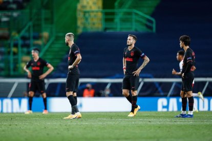 Jugadores del Atlético, que ayer vistió de azul, muestran su decepción por la derrota.