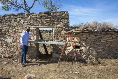 El alcalde, Jaume Pané, junto a una de las cabañas que restauran.