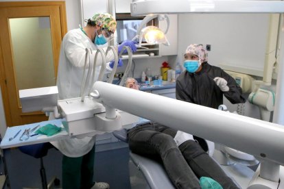 Dos professionals d’una clínica dental de Lleida ciutat atenent un pacient ahir a la tarda.