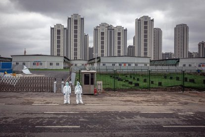 Dos vigilantes frente al hospital que China construyó en Wuhan. 