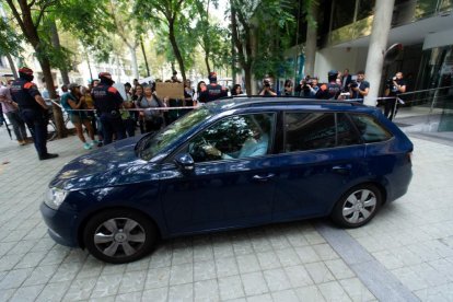 Momento en el que la menor uruguaya de siete años sale el mediodía de este viernes del edificio del consulado del Uruguay en Barcelona en el interior de un turismo.