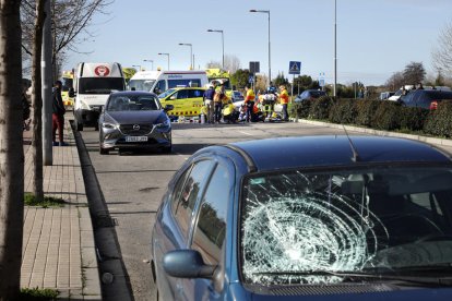 El vehicle del conductor ara empresonat i, al fons, l’atenció a la víctima.