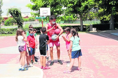 Un monitor junto a un grupo de menos de diez niños con mascarilla ayer en las ‘estades’ del Sícoris. 