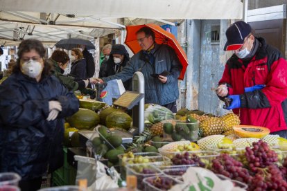 Paradistas y compradores, en su mayoría con mascarillas.