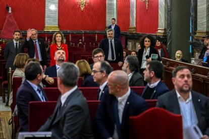 Els 12 líder independentistes, aquest dimarts a la banqueta dels acusats en la primera jornada del judici, amb el president Torra, al fons de la imatge, entre els assistents.