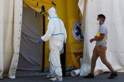 Un sanitario ataviado con el traje de protección entrando en la carpa del CUAP de Prat de la riba.