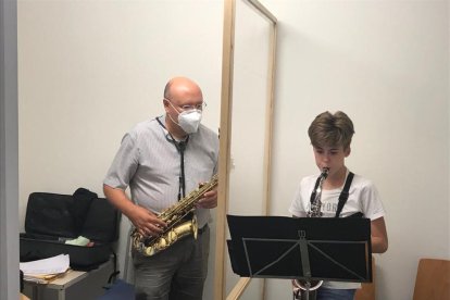 Un professor de l’Escola Municipal de Música de Balaguer, fent classes de saxo rere una mampara.