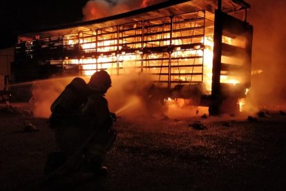 Un bomber sufocant ahir l’incendi que va calcinar part del camió.