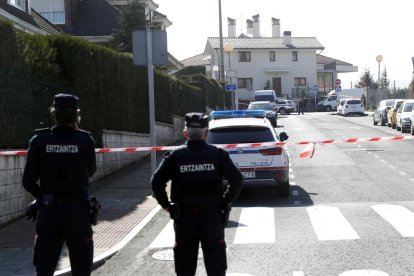 Dos agentes de la Ertzaintza en la zona acordonada junto a la vivienda donde hallaron los cuerpos.