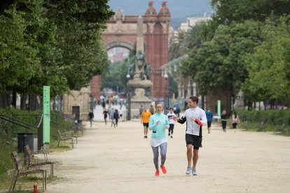 Decenas de personas paseando o practicando deporte en el parque de la Ciutat Vella de Barcelona.