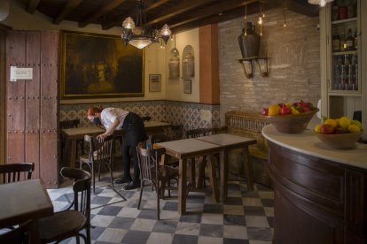 Una cambrera desinfecta les cadires en un bar de Sevilla.