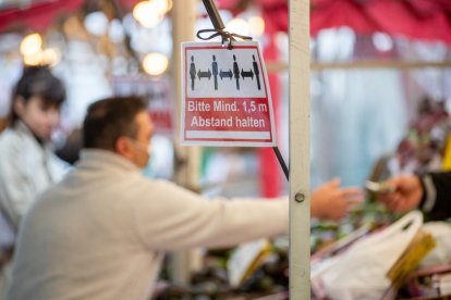 Un cartel pide mantener la distancia en un mercado alemán.