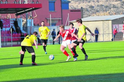 Un jugador de l’Artesa de Segre encara i retalla davant la pressió de dos defensors del Juneda.