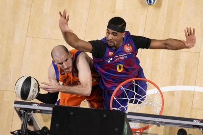 Quino Colom, excanterano del Lleida Bàsquet, intenta anotar ante la oposición de Brandon Davies.