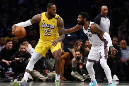 Kyrie Irving, jugador de los Nets, defiende a LeBron James durante un encuentro de la NBA.