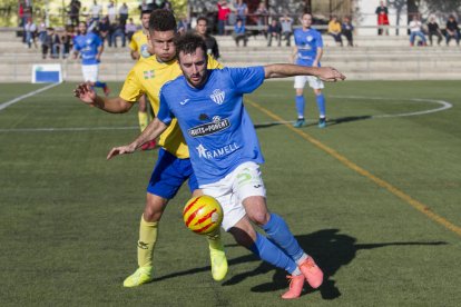 Un jugador de l’Alcarràs protegeix la pilota davant la pressió d’un del Catllar.