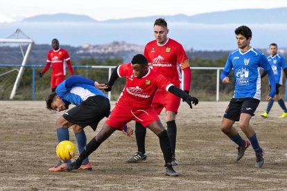 Un jugador del Sant Guim intenta controlar la pilota davant la pressió dels rivals. 