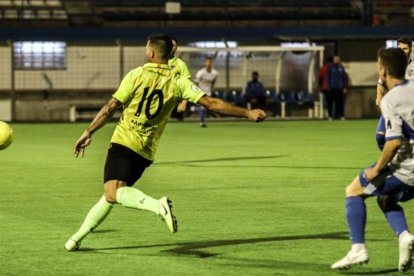 Un jugador de l’Igualada es disposa a picar la pilota amb un defensa del Mollerussa darrere.