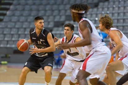 Agustí Sans busca un company a qui passar la pilota durant el partit amb el Benicarló.