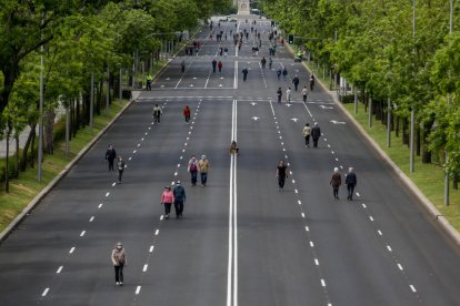 Transeünts caminen per un dels carrers convertits en zona de vianants a Madrid per mantenir el distanciament social.