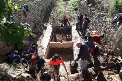 Veïns i veïnes del Taladell, treballant per netejar el safareig.