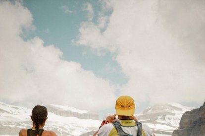 Sílvia Puigarnau y Òscar Balsells contemplan la majestuosidad del Pirineo oscense. Derecha, durante un descanso para avituallarse.