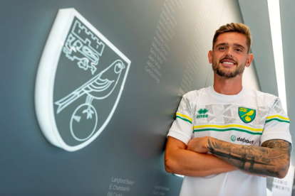 Xavi Quintillà posa junto al escudo del Norwich City, equipo en el que jugará esta temporada.