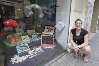 La librera de El Genet Blau, Marina Guillén, junto al escaparate distinguido por la Setmana del Llibre.