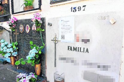 Una de las lápidas del cementerio con un cartel.