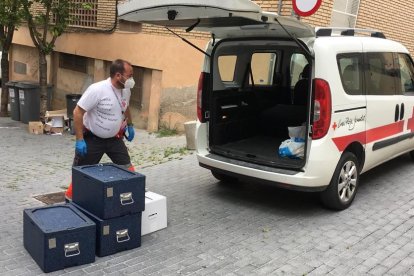 Un voluntario de Creu Roja Lleida repartiendo alimentos para los usuarios del comedor social Jericó, este verano.