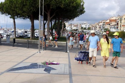 Turistes passen per la placa en record de l’atac jihadista a Cambrils, ahir.