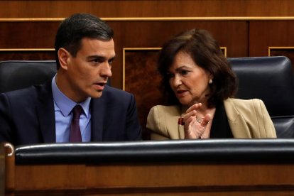 El presidente del Gobierno, Pedro Sánchez, conversa con la vicepresidenta, Carmen Calvo, durante un pleno del Congreso.